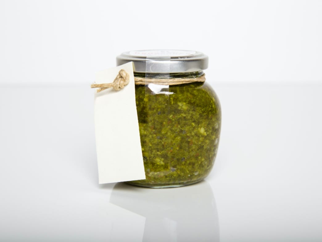Jar of spinach basil pesto with a blank label