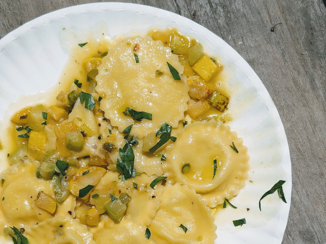 Plate of ravioli with vegetables and herbs