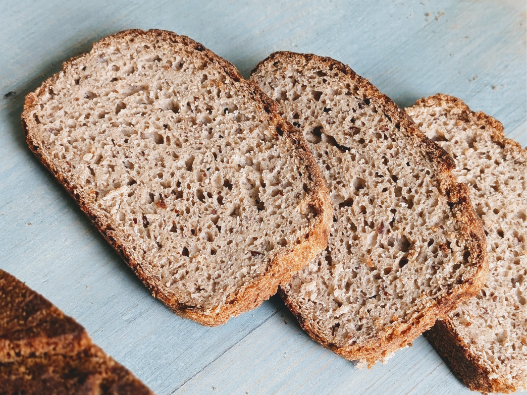 Three slices of gluten-free bread on a wooden surface.