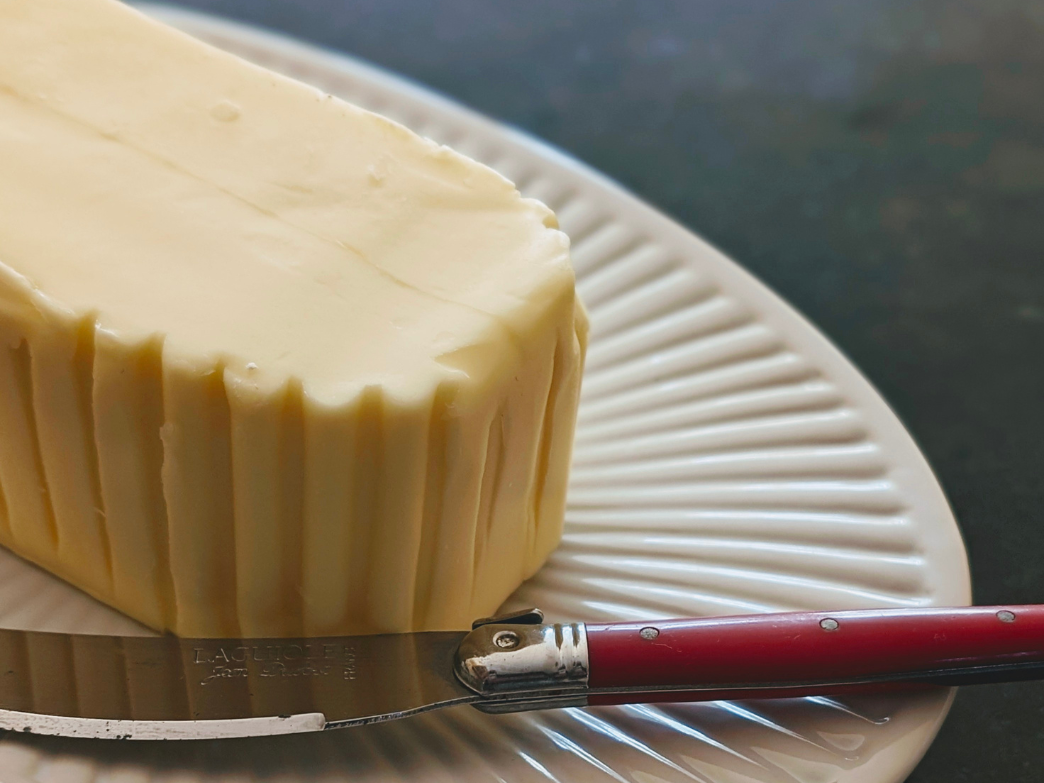 Block of butter on a plate with a knife