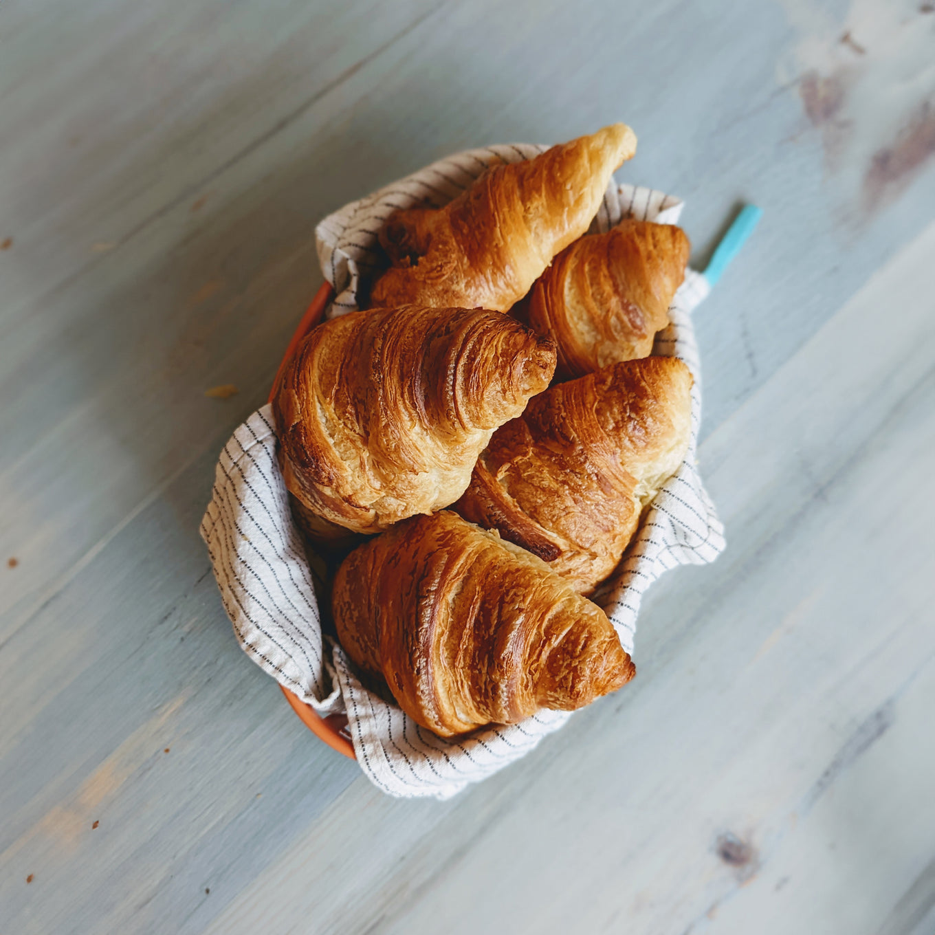 A basket of flaky plant-based croissants