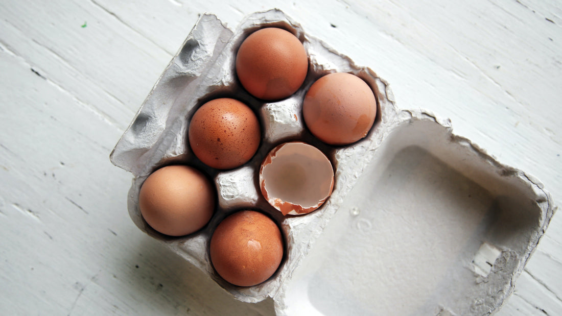 A carton of six eggs, one cracked, representing food myths about eggs.