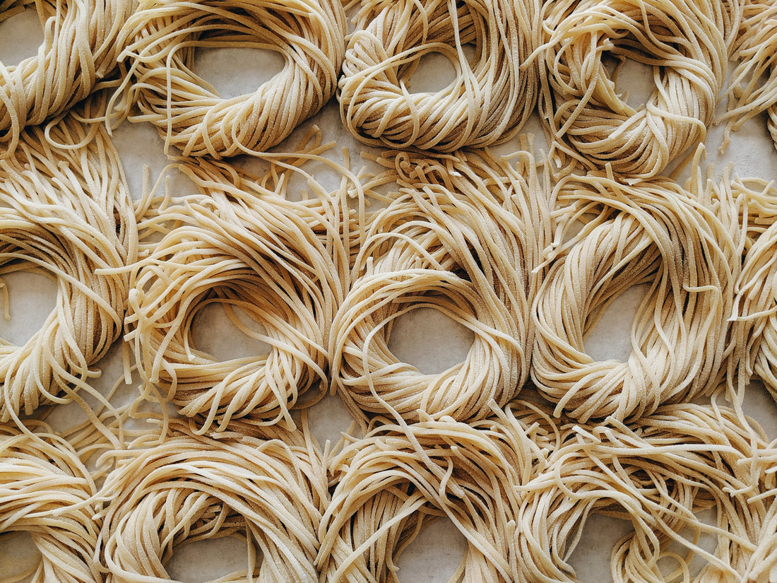 Close-up of uncooked pasta nests on a surface.
