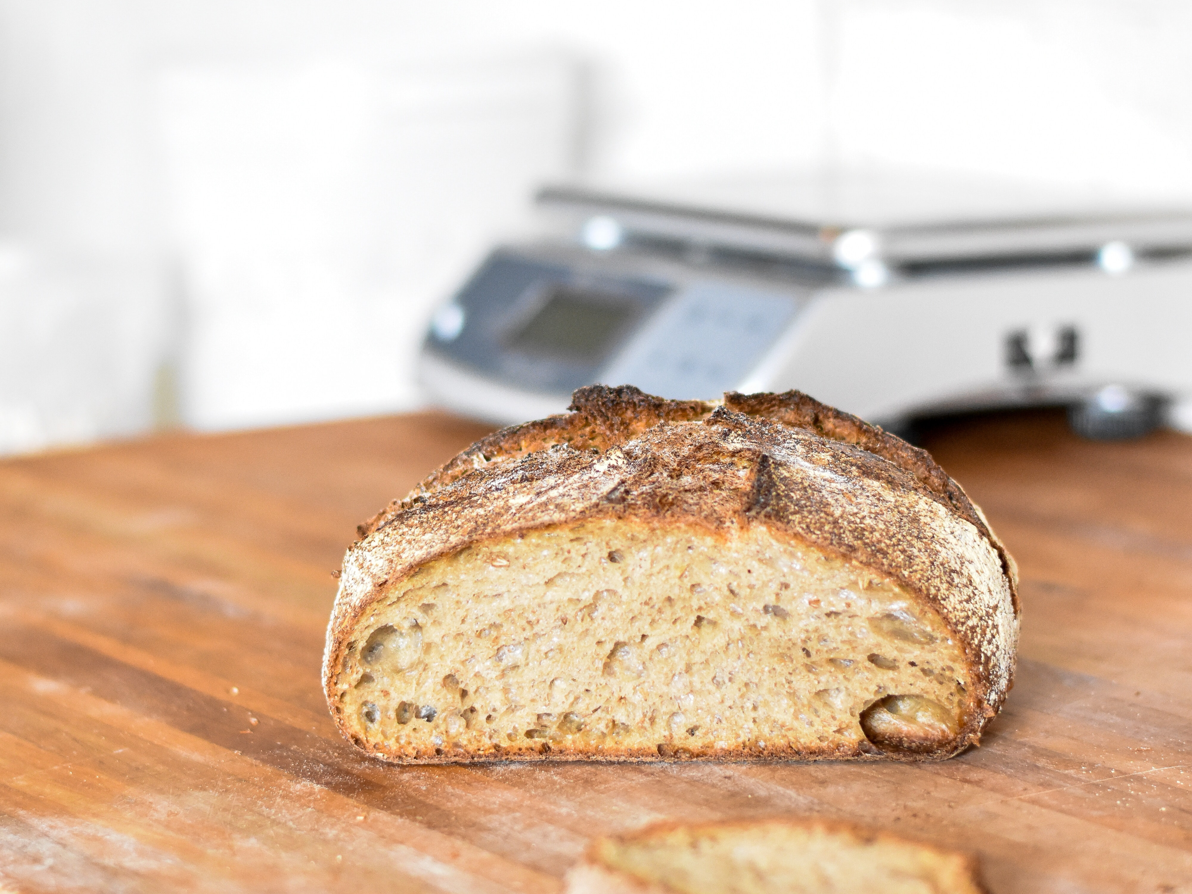 Sliced loaf of whole grain bread on a wooden cutting board