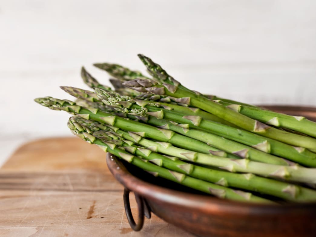Fresh asparagus in a bowl, a source of prebiotics.