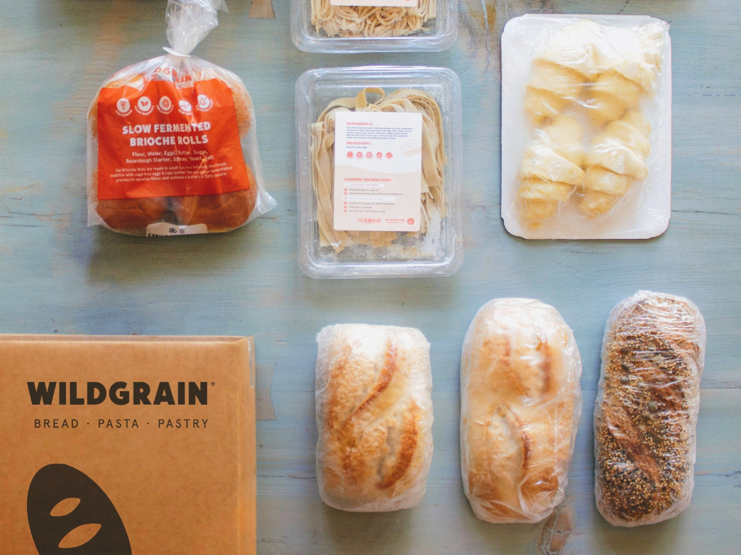 An assortment of frozen breads, including brioche rolls, pasta, and various loaves from Wildgrain.