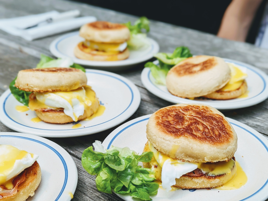 A plate of English muffins with eggs and greens, showcasing a breakfast dish.