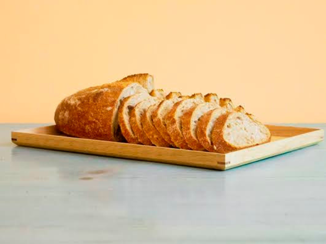 Sliced whole wheat sourdough bread on a wooden board