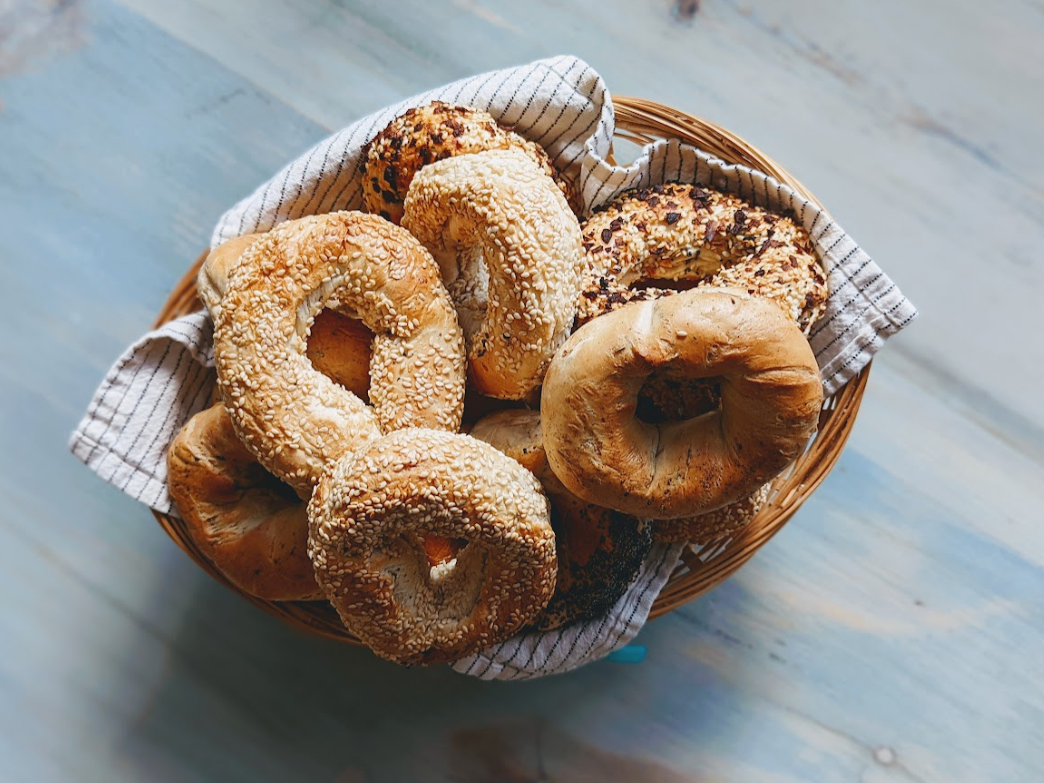 A basket of assorted bagels, including sesame and poppy seed varieties.