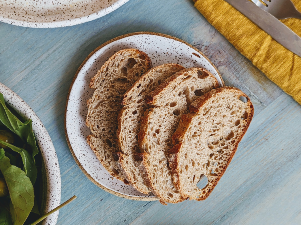 Four slices of whole grain bread on a speckled plate.