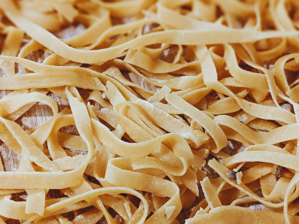 Close-up of uncooked fettuccine pasta on a wooden surface