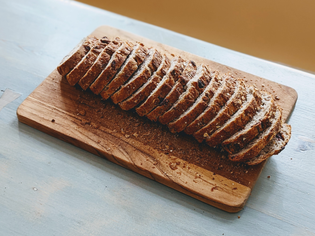 Sliced bread on a wooden board, showcasing a vegan dish.