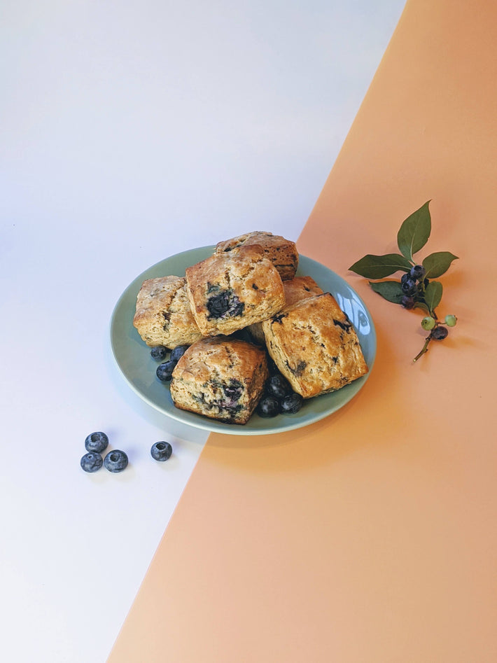 Blueberry biscuits on a plate with fresh blueberries