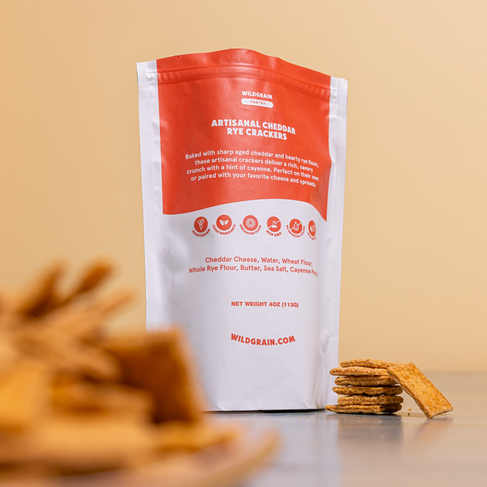 WILDGRAIN PANTRY bag labeled ARTISANAL CHEDDAR RYE CRACKERS; NET WEIGHT 4OZ (113G); WILDGRAIN.COM