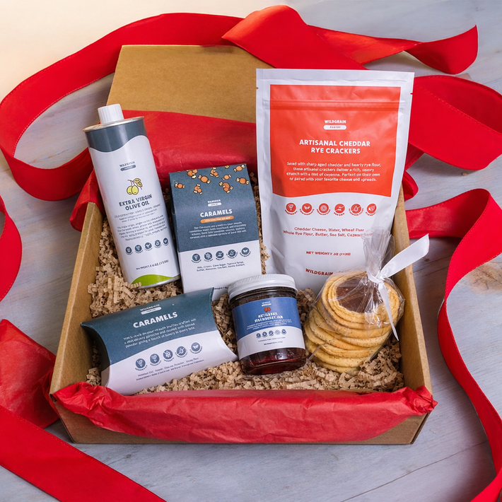 Gift box with snacks and a bottle, surrounded by red ribbons on a light background