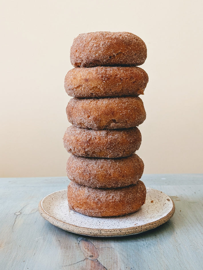 Apple Cider Donuts (6-pack) stacked on a plate, sugar-coated.