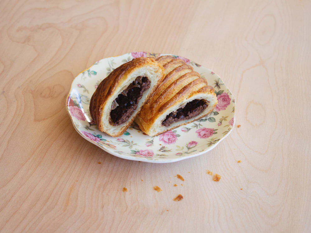Chocolate Avalanche Croissant on a floral plate, showing chocolate filling