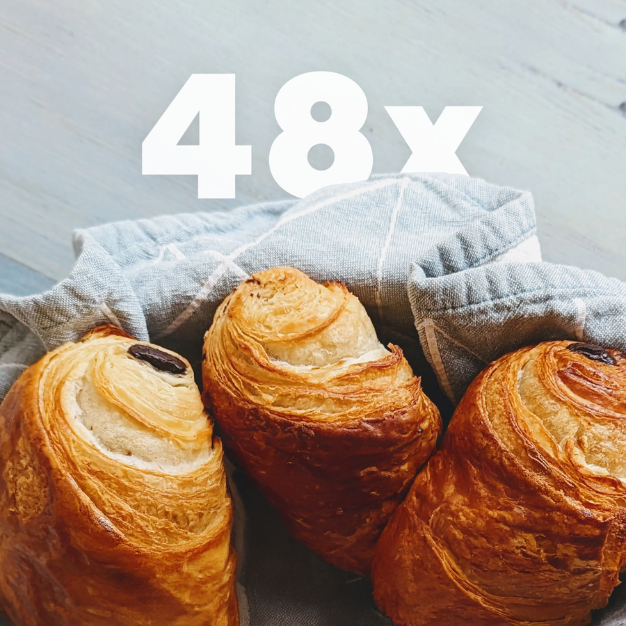 Close-up of 4 Dozen Chocolate Croissants (48-pack) showcasing flaky golden crusts and chocolate filling with gray cloth background and large white 48x overlay
