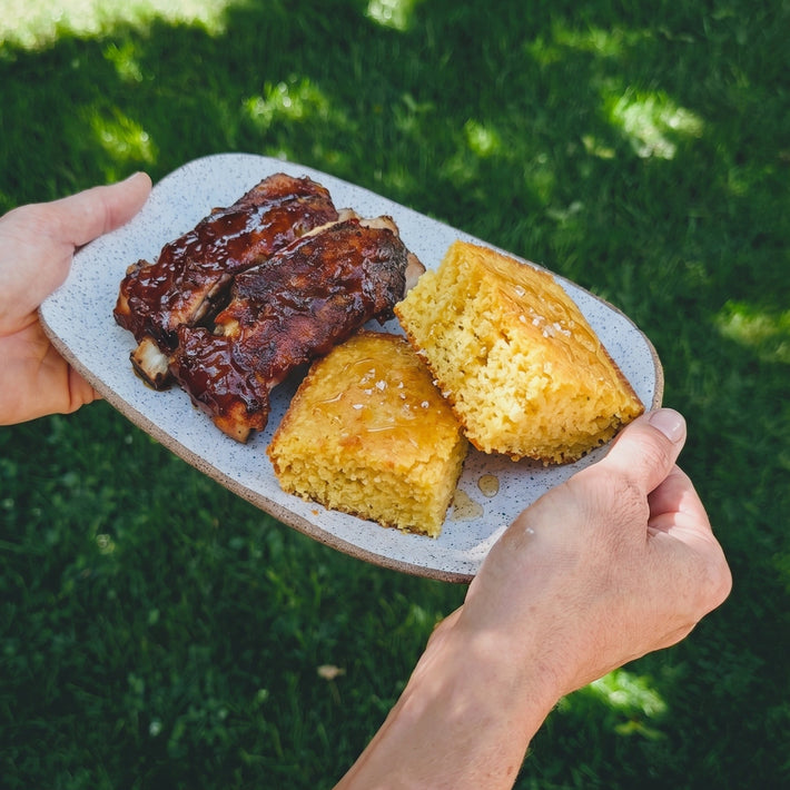 Overhead view of mild jalapeno cornbread showcasing its crumb texture on a plate outdoors