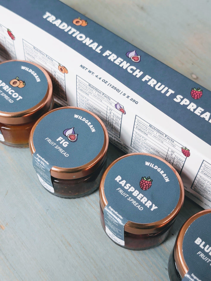 Angled view of Traditional French Fruit Spreads sampler showing apricot, fig, raspberry, and blueberry jars