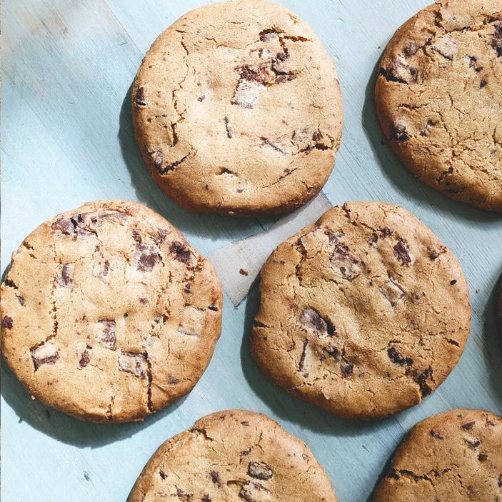 Gluten-Free Giant Chocolate Chunk Cookies on a light blue surface.