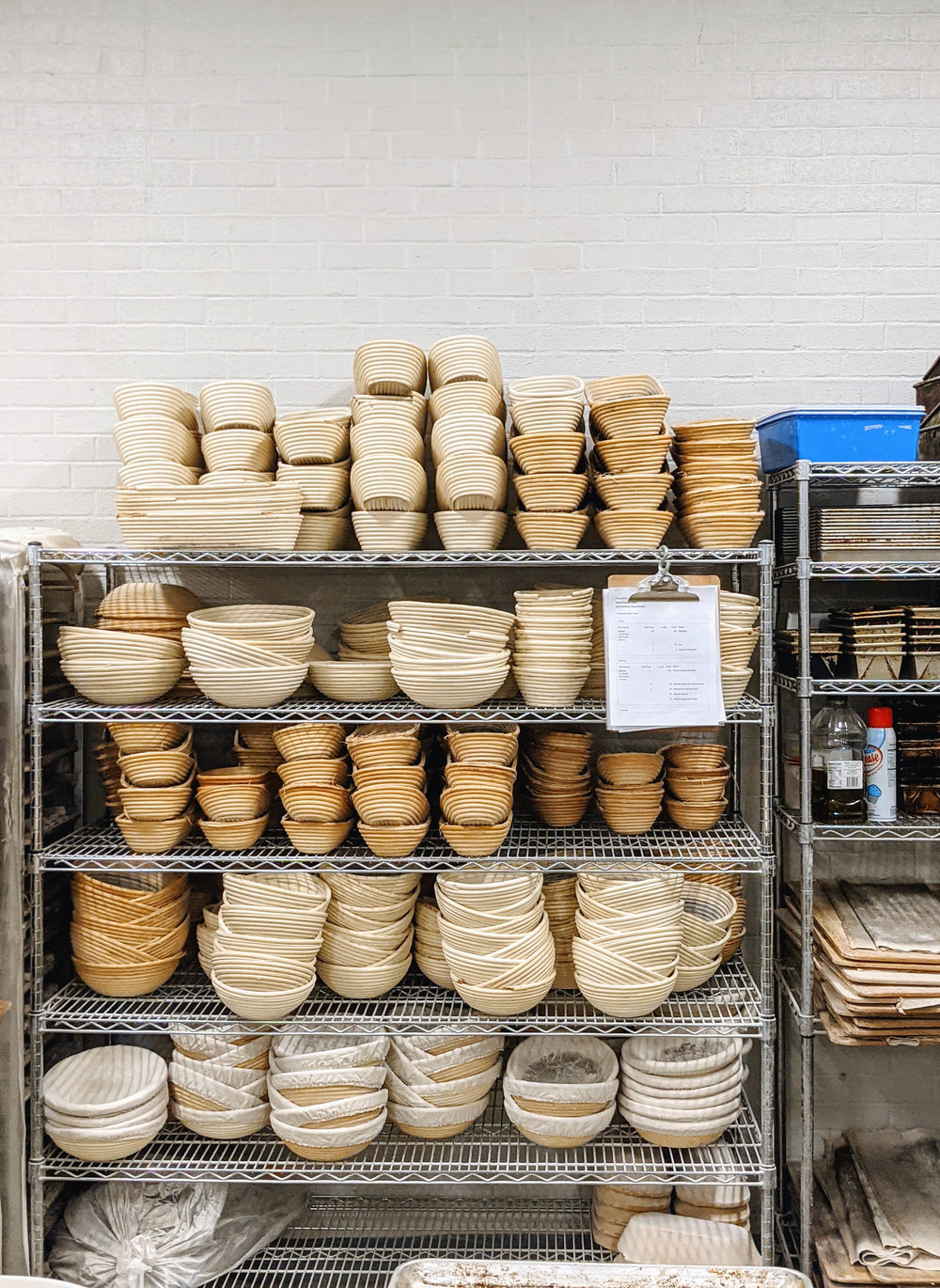 A shelf filled with various round proofing baskets used for bread making.