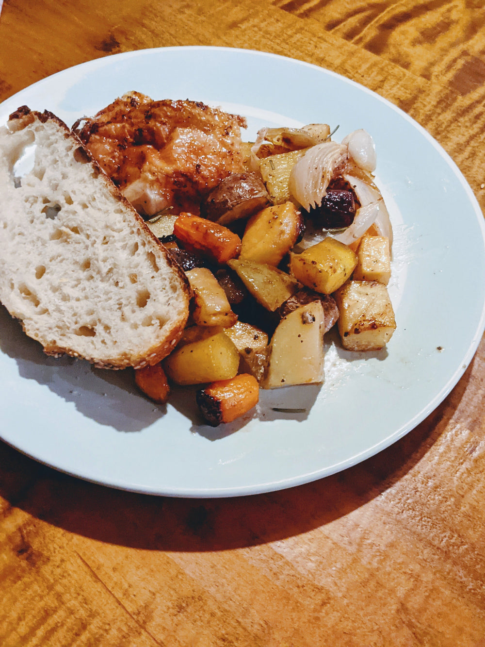 A plate with roasted vegetables and a slice of sourdough bread