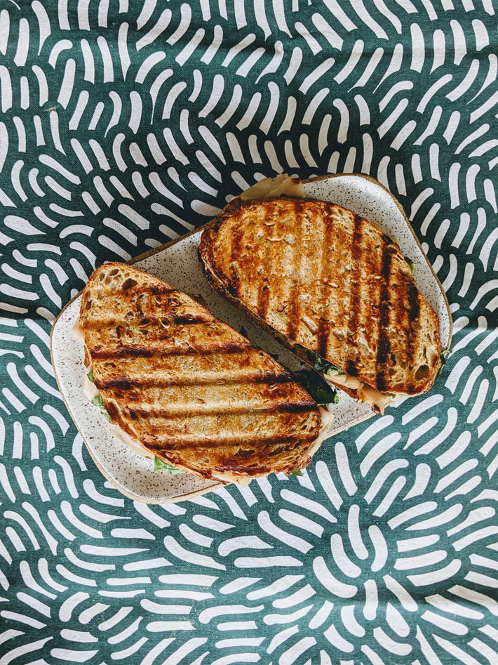 Grilled Plain Sourdough Loaf sandwich on a patterned tablecloth