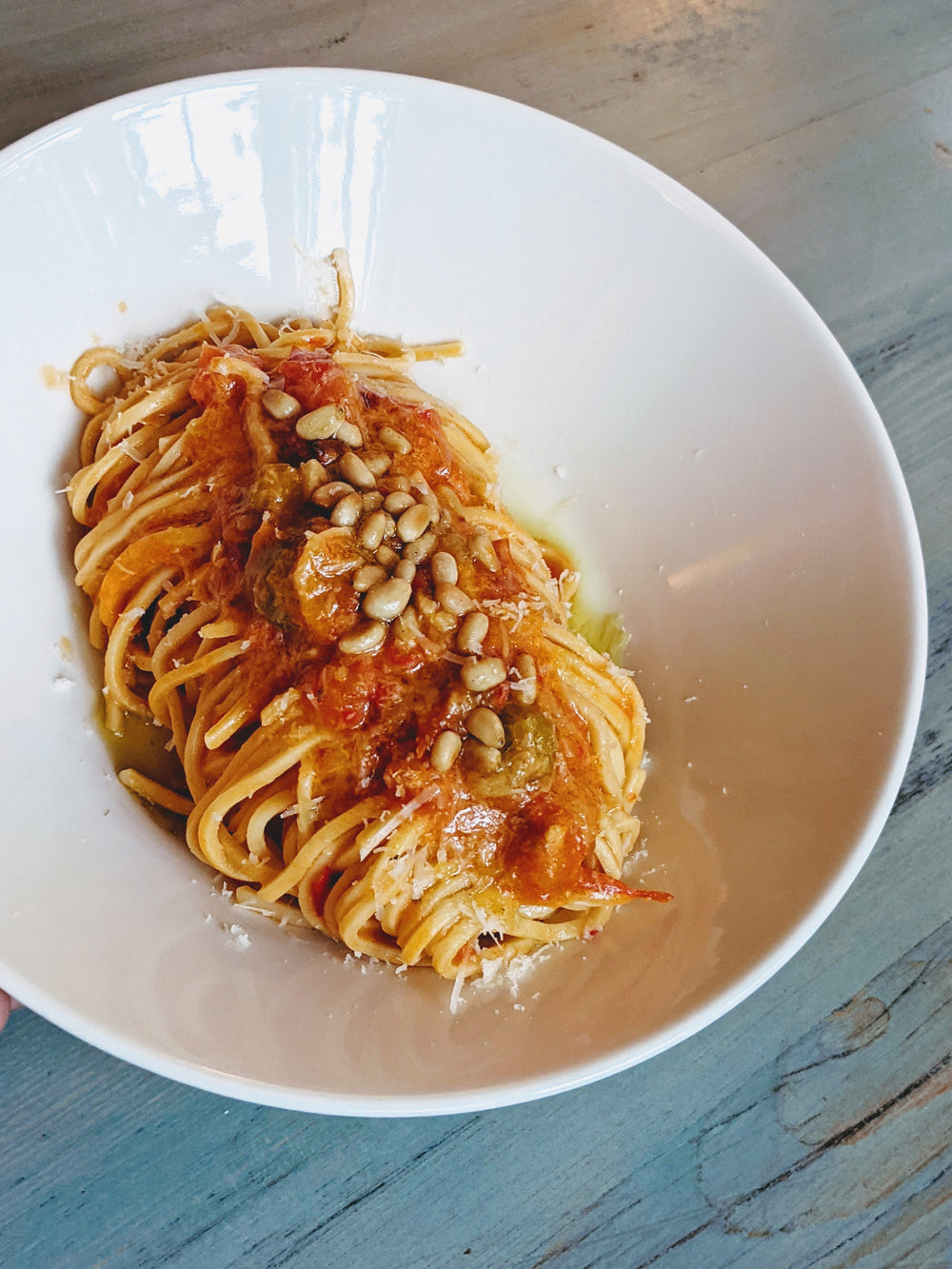 Fresh Tonnarelli pasta topped with tomato sauce and pine nuts