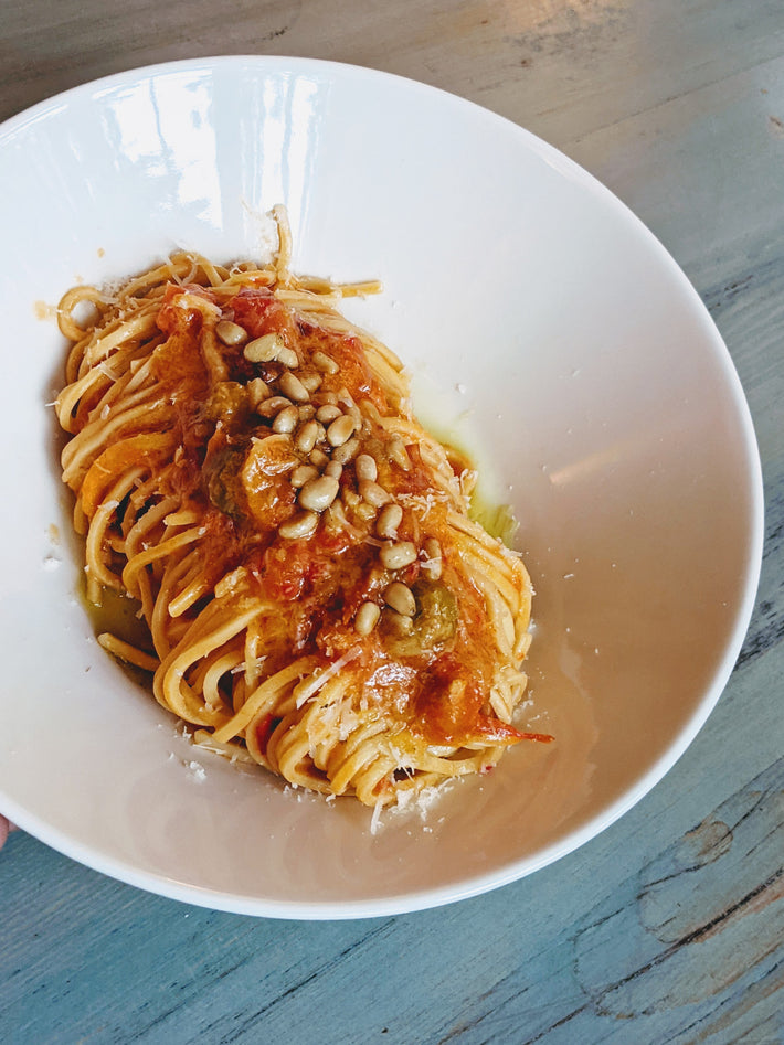 Fresh Tonnarelli pasta topped with tomato sauce and pine nuts