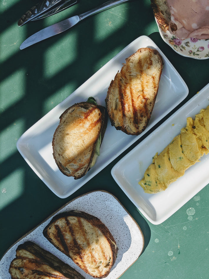 Grilled ciabatta bread with an omelette and a spread on a green table