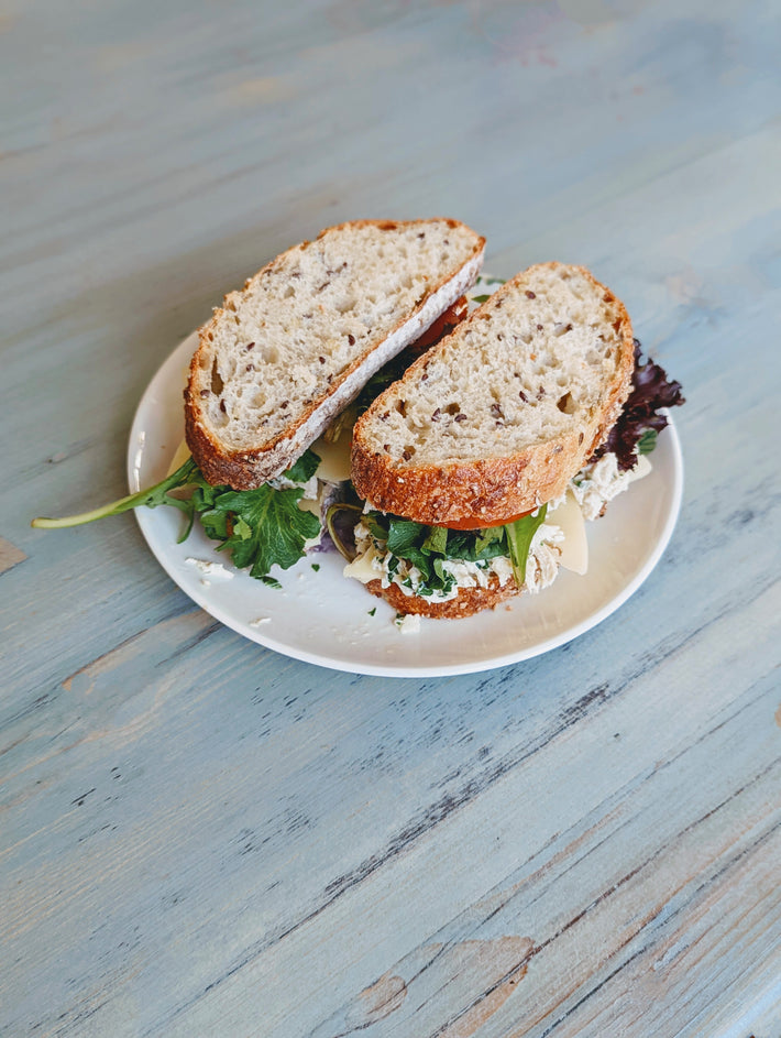 Wildgrain sandwich with leafy greens and filling on a plate