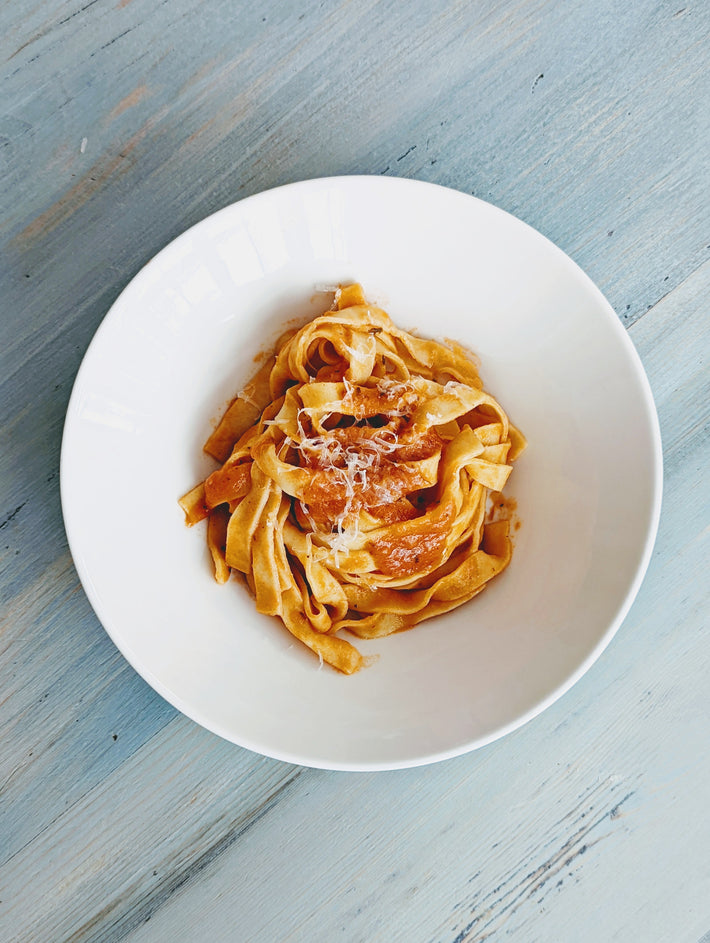 Fettuccine pasta with sauce and cheese in a white bowl