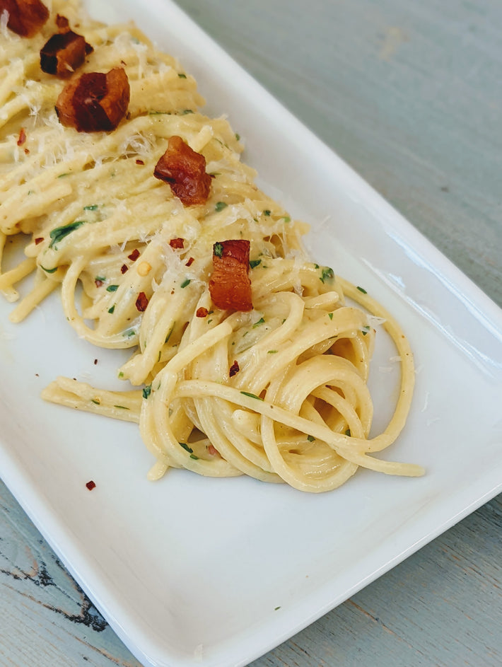 Fresh Tonnarelli pasta topped with crispy bacon and herbs