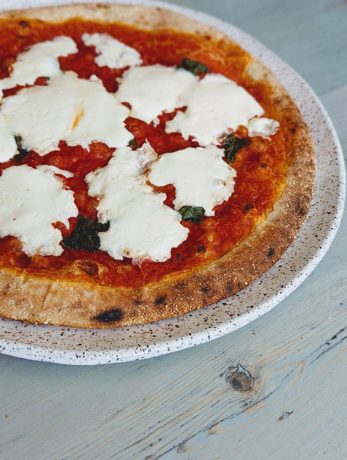 Slow-Fermented Margherita Pizza with mozzarella, tomatoes, and basil on a crust