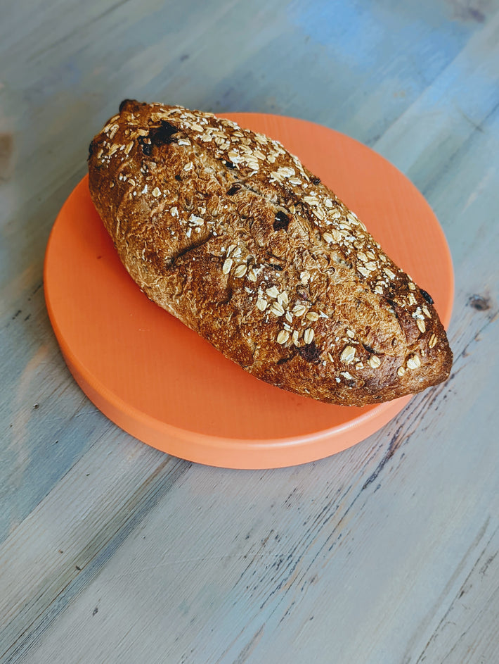 Wildgrain Cranberry-Pecan Sourdough Loaf on an orange plate