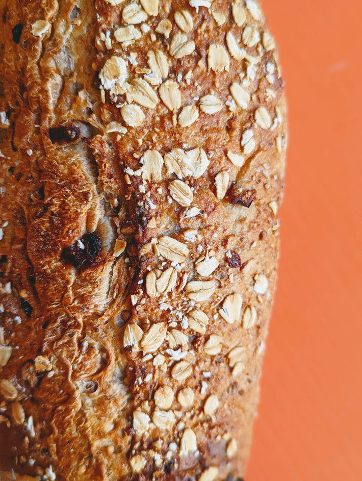 Close-up of a crusty bread loaf topped with oats