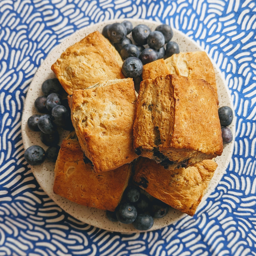 Blueberry biscuits on a plate with fresh blueberries