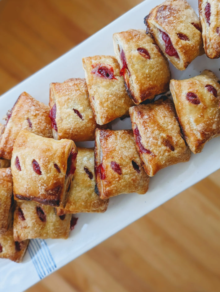 A plate of pastries, including fruit-filled pastries, arranged neatly.