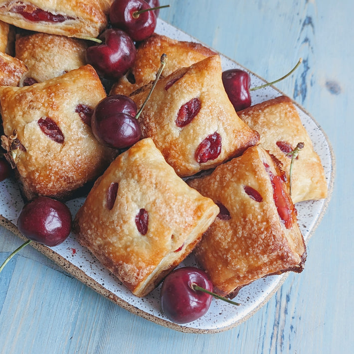 Cherry Pie Bites with fresh cherries on a plate