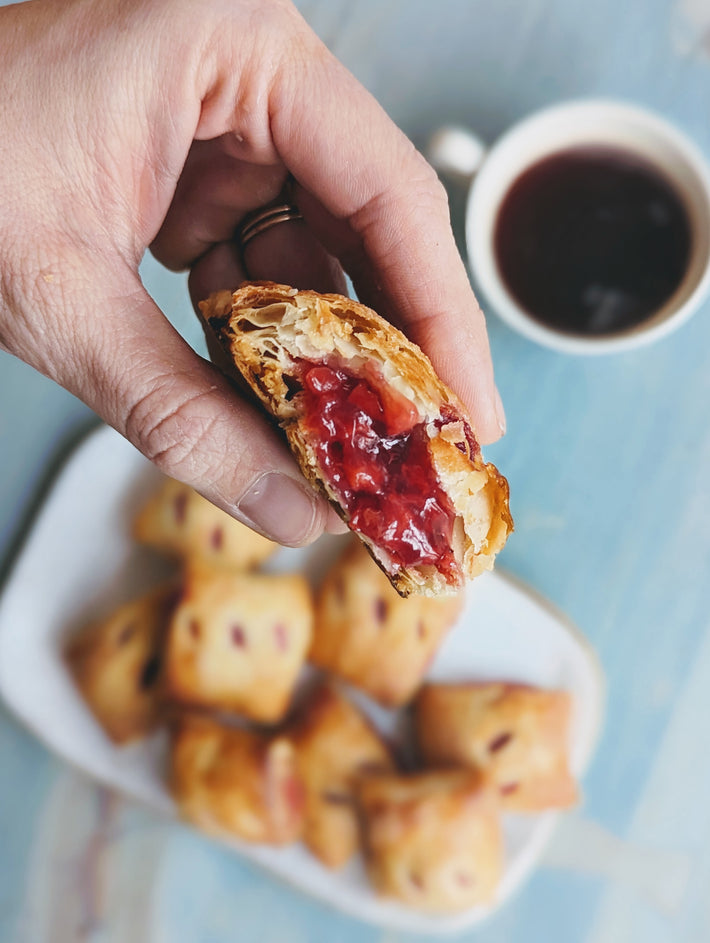 Hand holding a Cherry Pie Bite, revealing the cherry filling