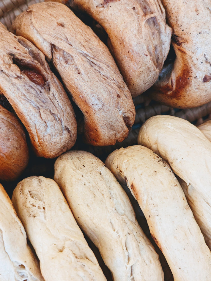Close-up of Wildgrain wood-fired cinnamon raisin bagels and plain bagels