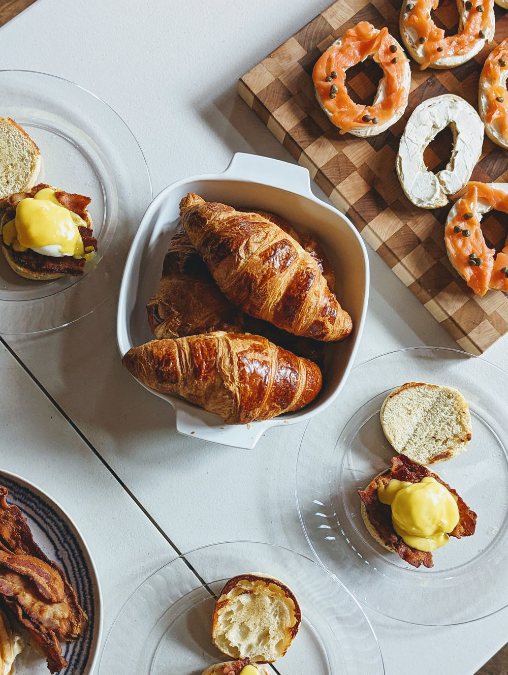 Croissants and bagels with toppings on a table
