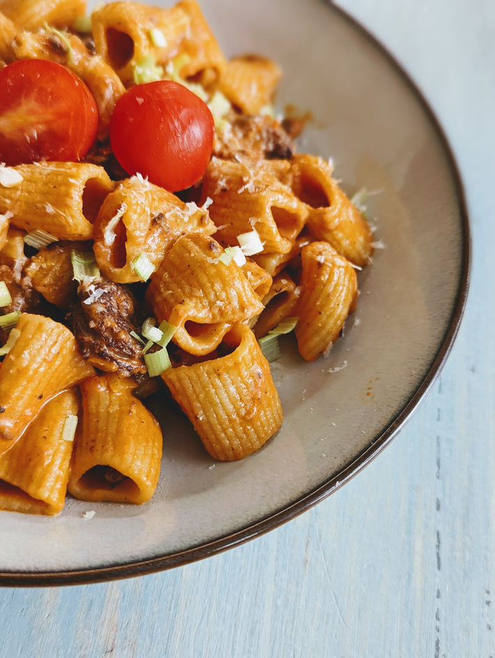 Rigatoni pasta with cherry tomatoes and herbs on a plate