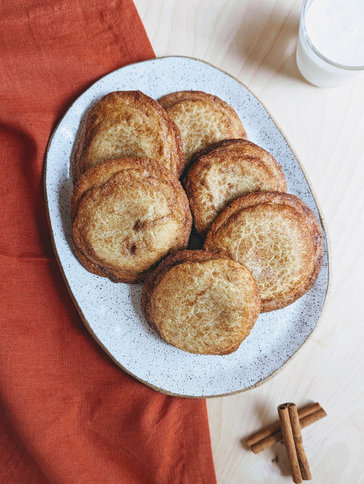 A plate of Giant Snickerdoodle Cookies with a cinnamon stick on the side