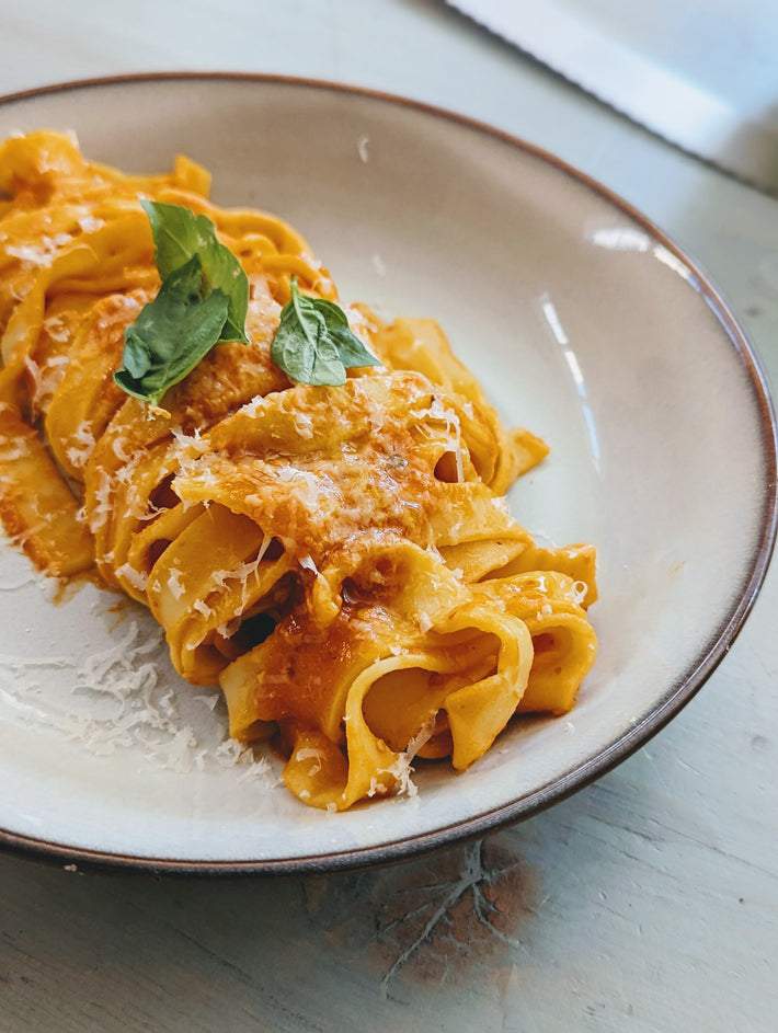 Pappardelle pasta with sauce and basil on a plate