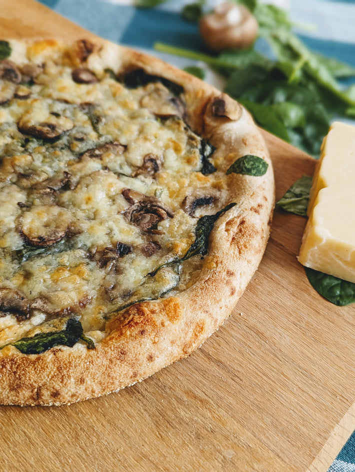 Slow-Fermented Veggie Pizza with mushrooms and cheese on a wooden board