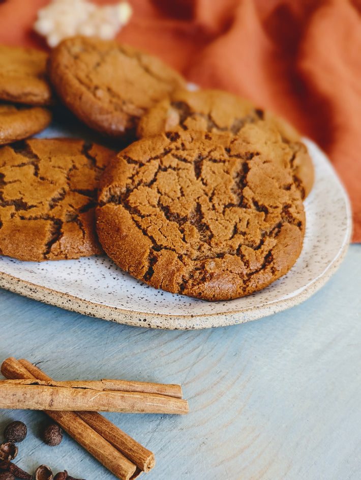 Giant Ginger Molasses Cookies on a plate with cinnamon sticks