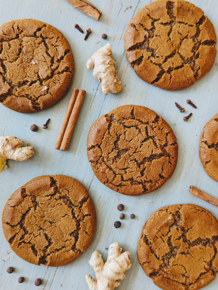 Giant Ginger Molasses Cookies arranged with ginger and spices