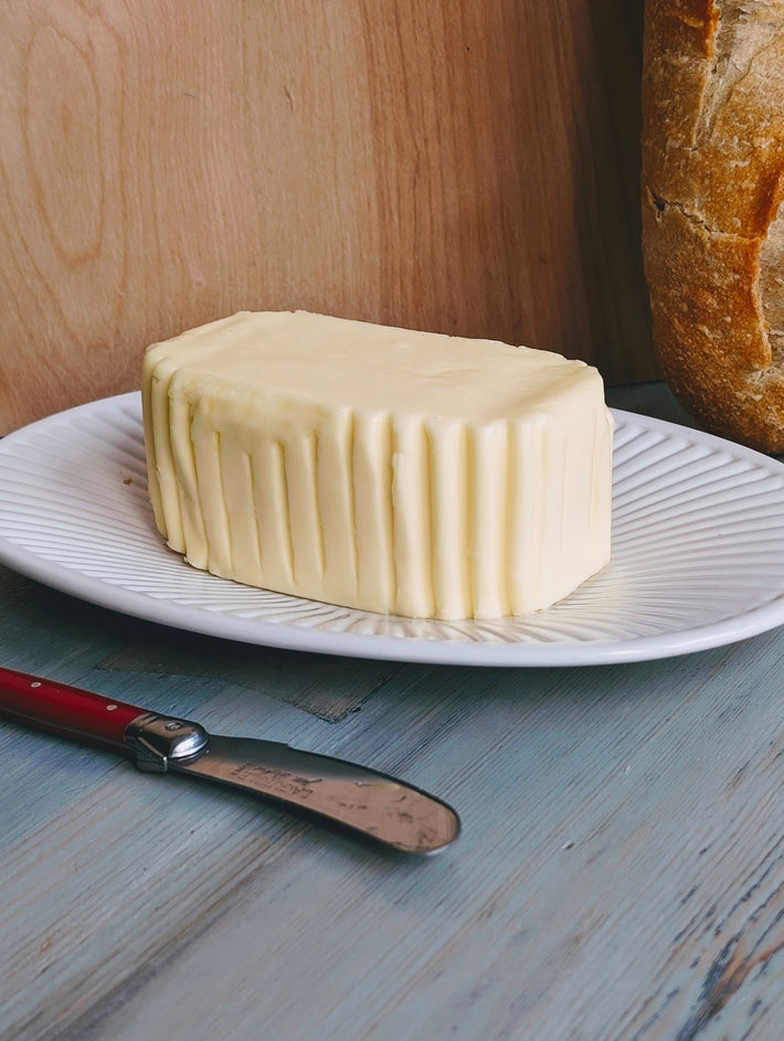 Block of Slow-Churned French Butter on a plate with a knife